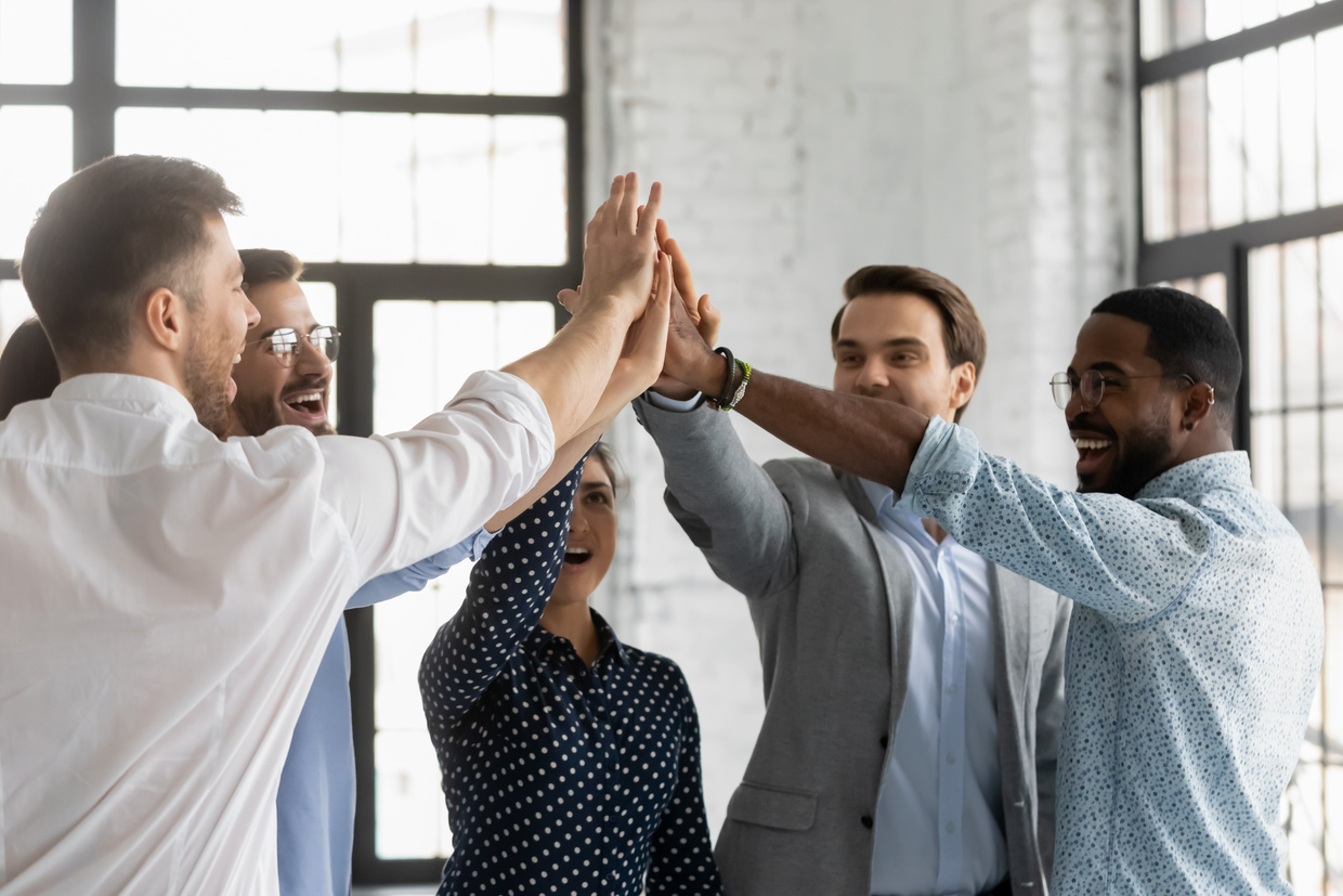 Multiracial affiliates join hands giving high five celebrating common success